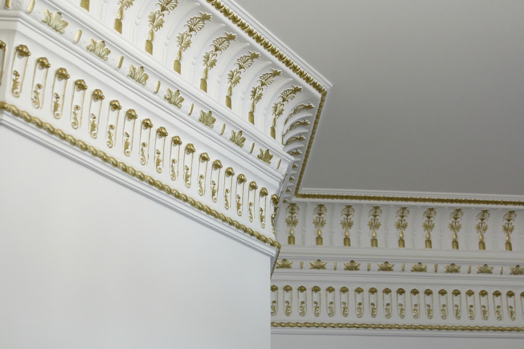 Two corners of a palmette cornice in perspective, white and gold